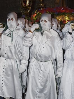 Easter nazarenes in white robe in a typical Spanish procession. 