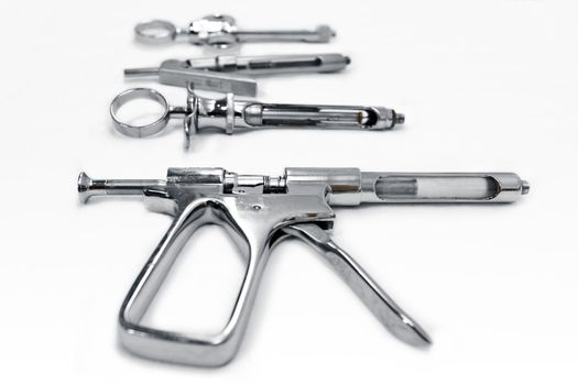 Metal cartrige syringe for intraligametous anesthesia with  other injector types on background with shallow focus