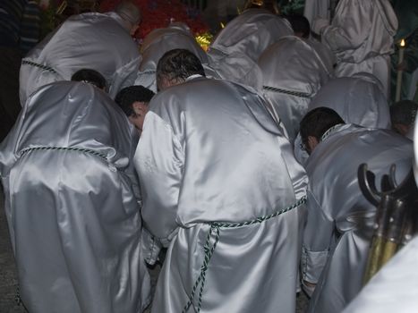 Easter nazarenes in white robe in a typical Spanish procession. 