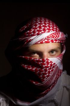 Close-up photograph of a man in a red keffiyeh.