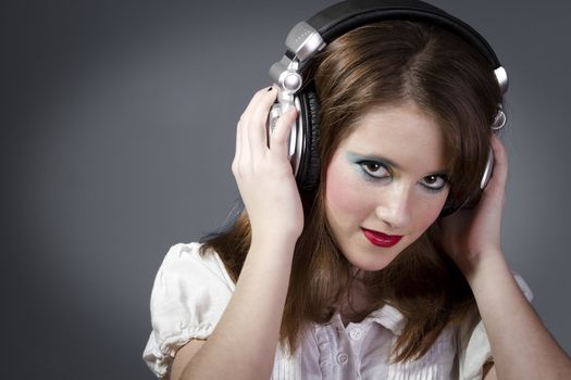 Young teen in headphones on a grey background