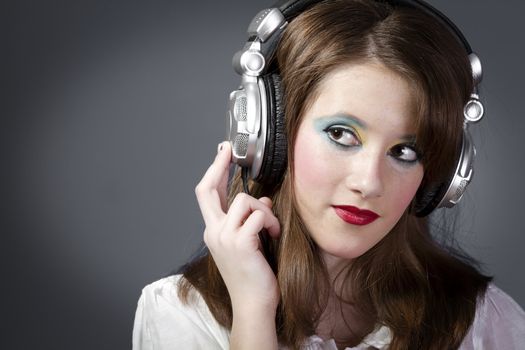 Beautiful Girl listening music over grey background