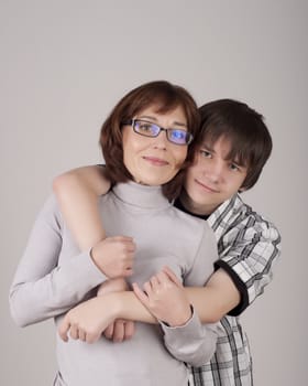 mother and son are together and smile in studio