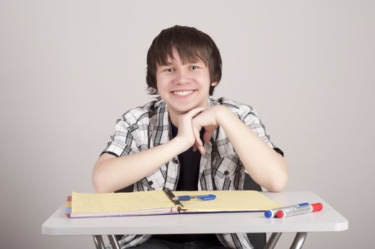 student in exams, sits at the table and reading a book