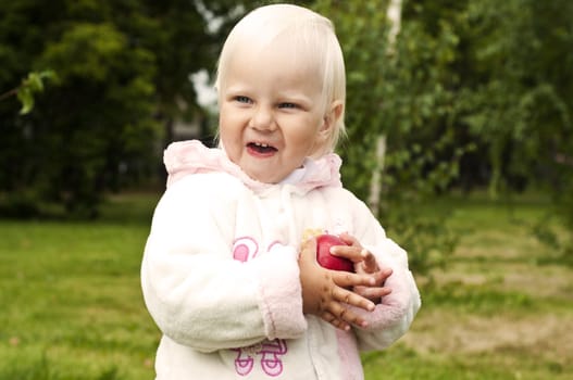 Full length portrait of a young blond girl poses in the park