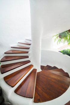 White and wood spiral staircase in modern interior. Vertical view