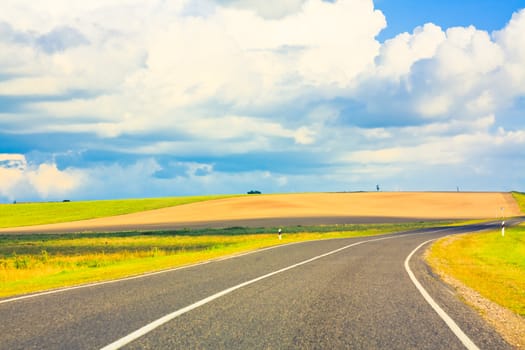 Open road highway with green grass and asphalt street representing the concept of journey to a focused destination resulting in success and happiness.