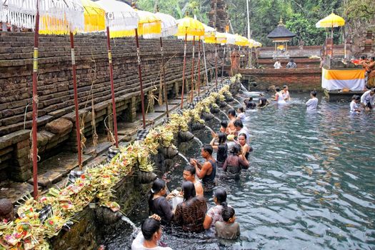 TAMPAK SIRING, BALI, INDONESIA - OCTOBER 30: People praying at holy spring water temple Puru Tirtha Empul during purification ceremony on October 30, 2011 in Tampak Siring, Bali, Indonesia