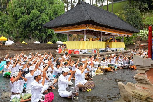 TAMPAK SIRING, BALI, INDONESIA - OCTOBER 30: People praying at holy spring water temple Puru Tirtha Empul during purification ceremony on October 30, 2011 in Tampak Siring, Bali, Indonesia