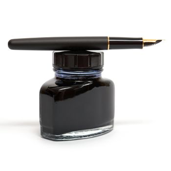 fountain pen lying on the ink bottle