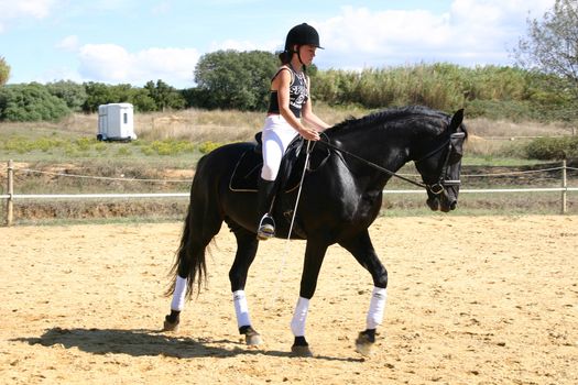 training in dressage for a black horse and her riding girl