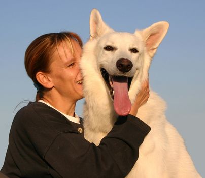 Purebred White Swiss Shepherd and woman in blue sky