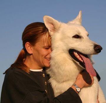 Purebred White Swiss Shepherd and woman in blue sky