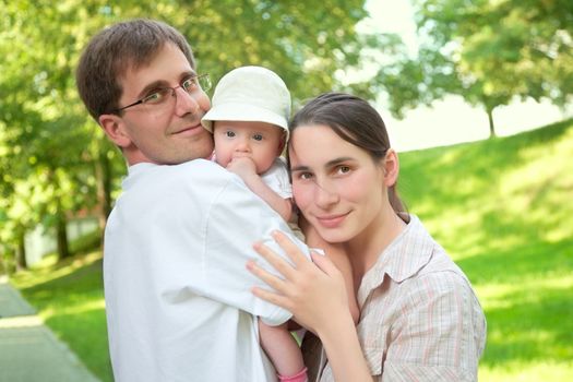 smiling young family with a baby