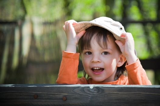 playful child holding his hat