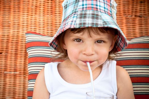 child drinking juice through a straw