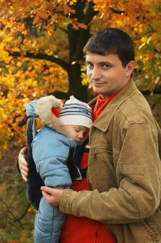 father holding his son in baby carrier