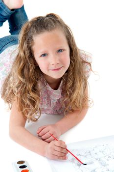 Close up Portrait of cute little girl laying on floor painting.Isolated on white background.