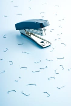 office stapler and many bent clips, blue color tones