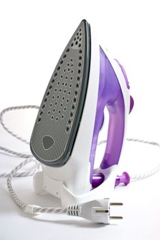 purple smoothing iron standing on a white table 