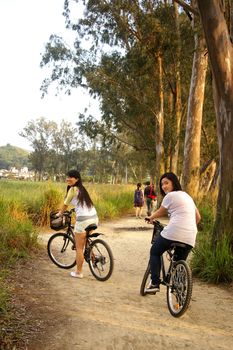 Asian friends riding bicycle
