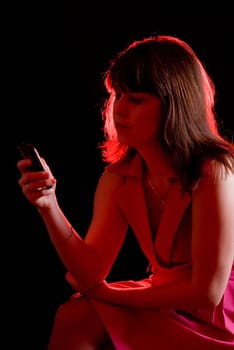 girl call by cell phone in red light on dark background