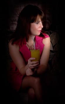 beautiful girl with cocktail sitting in dark room