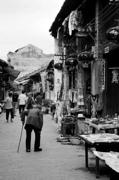 CHINA - MAY 17, An old woman is walking along the traditional street in Xingping, Yangshuo, China on 17 May, 2010.