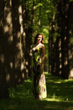 Woman stay on a shady park alley