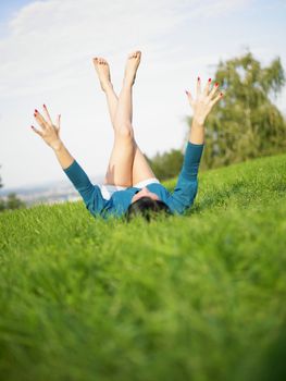 Young woman relaxing in park on green grass