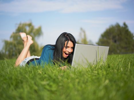 Young woman using laptop PC in park