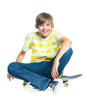 cute teenger blond boy on sitting on skateboard isolated on white background