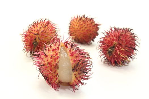 four fresh rambutan before a light background