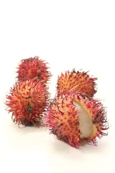 fresh red rambutan open in front of a light background