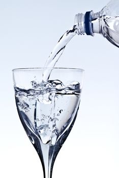 pouring water into glass, grey background