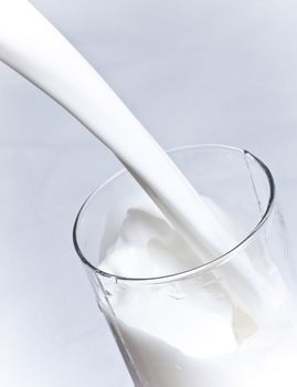 milk is poured into a glass closeup