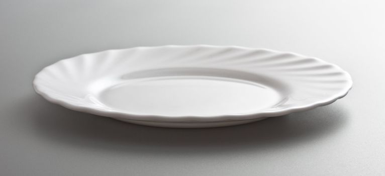 empty white dish, grey background