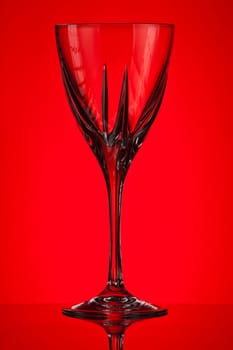 empty crystal glass on red background