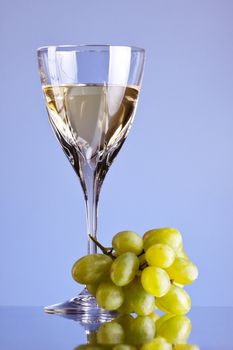 glass of white wine and grape, blue background