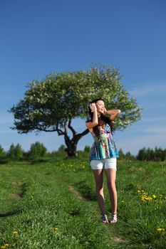 Young woman with headphones listening to music on field