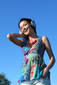 Young woman with headphones listening to music on field