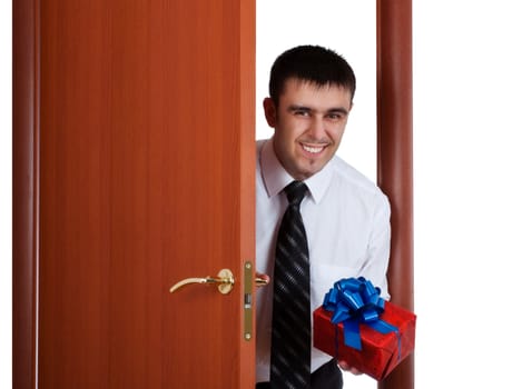 smiling young man with gift opening the door