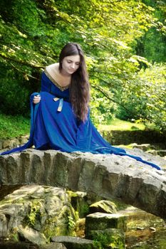 medieval princess on stone bridge at summer