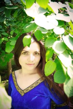 beautiful princess standing in shadow of leaves