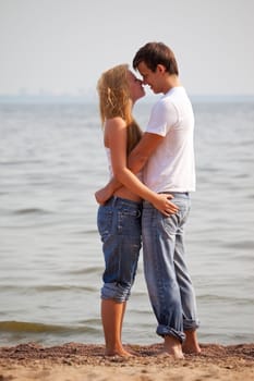 young couple embrace on a sunny beach