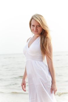 beautiful woman standing on seashore, high key