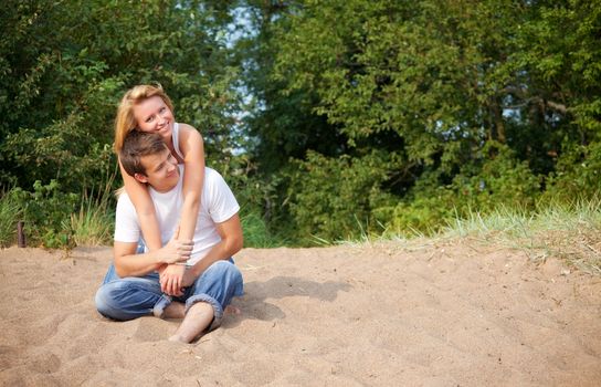 young couple sitting on a sand