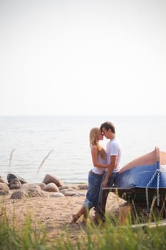 beautiful couple on a beach near old boat