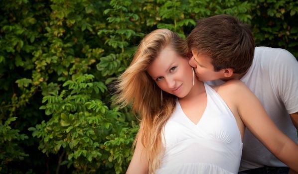 young man kiss sly girl in cheek