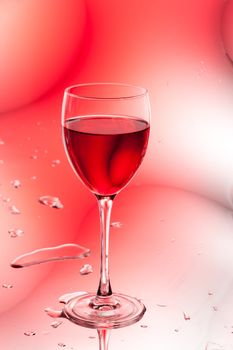glass of red wine on abstract colorful background